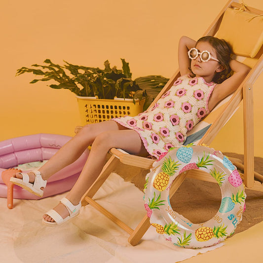 Niña usando sandalias infantiles Coqueta y Audaz de piel color blanco con suela ligera, diseño fresco y cómodo ideal para vacaciones de primavera verano.