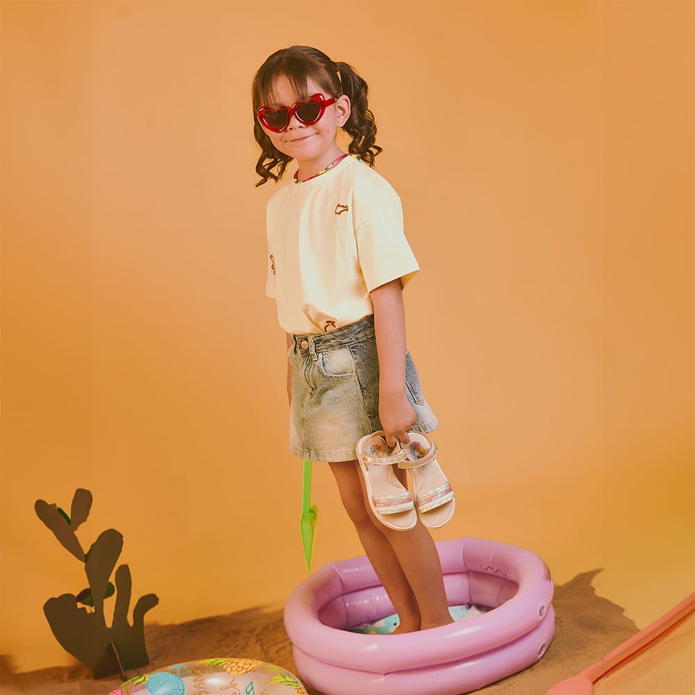 Niña con sandalias infantiles Coqueta y Audaz en color tornasol, calzado ligero y cómodo ideal para verano, playa y actividades al aire libre.