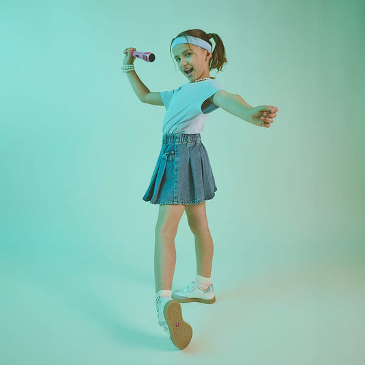 Niña usando tenis Coqueta y Audaz color blanco con detalles en plata, diseño ligero y cómodo ideal para moverse con libertad en sus actividades diarias.